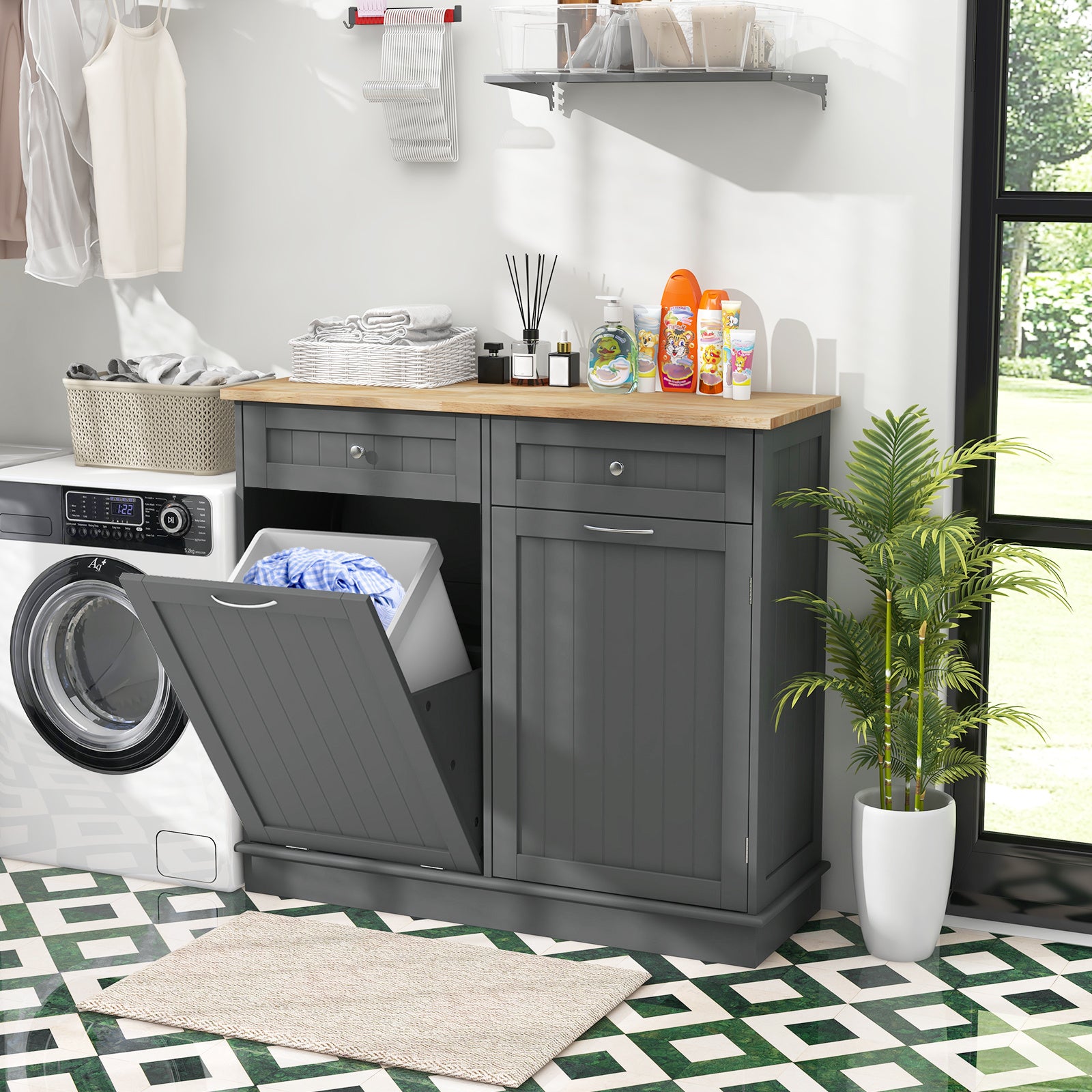 Nutshell tilt-out trash cabinet in modern kitchen setting with laundry appliances and storage items