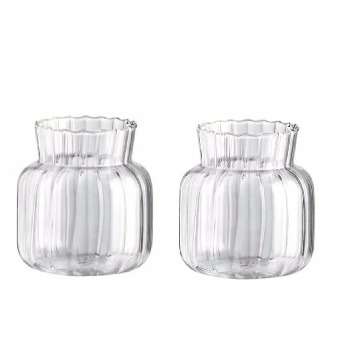 Set of two transparent glass vases for flowers with ribbed design and fluted edges