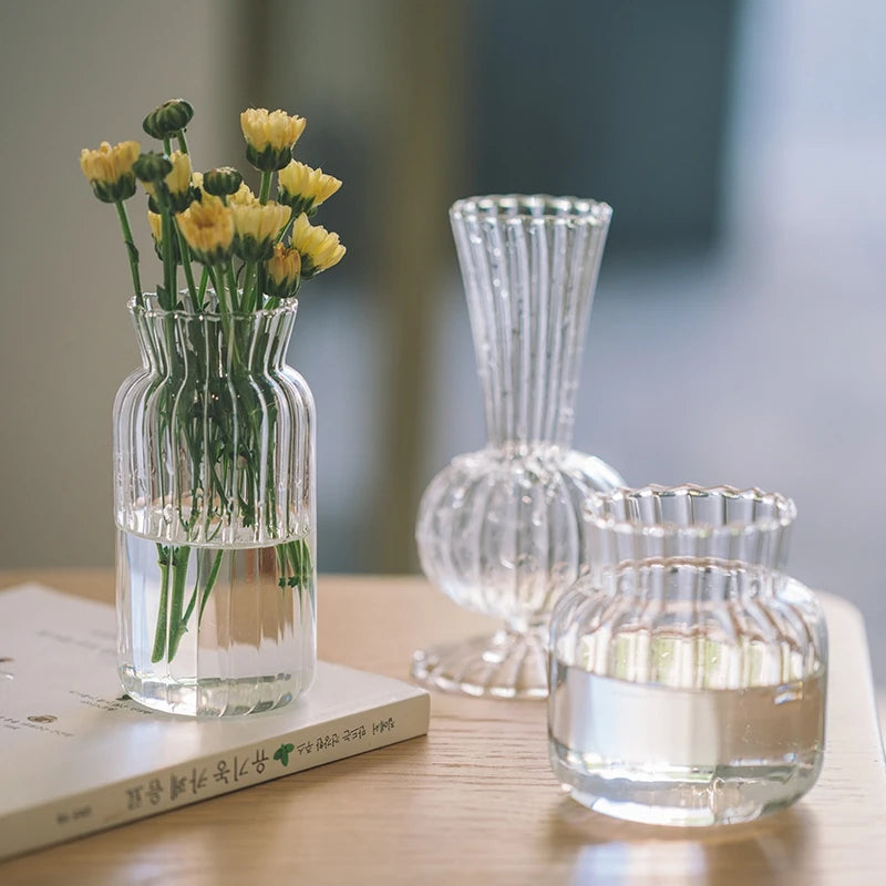 Elegant transparent glass vase for flowers featuring a ribbed design and water for a beautiful floral display