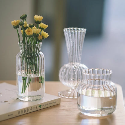 Elegant transparent glass vase for flowers featuring a ribbed design and water for a beautiful floral display