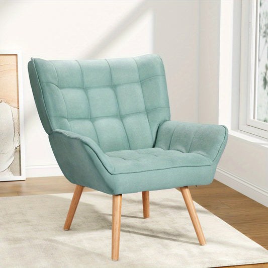 Nutshell tufted wingback armchair in light blue fabric with wooden legs in a bright room