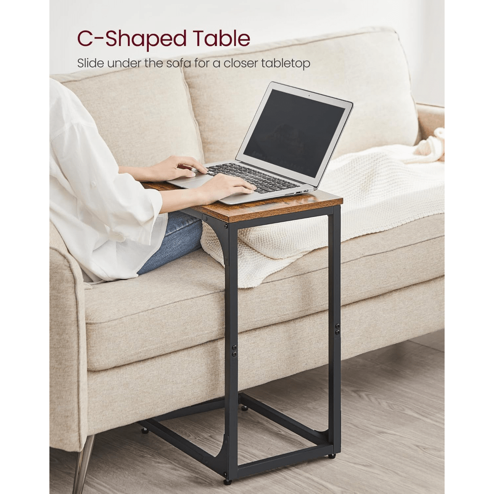 C-shaped sofa side table set placed beside a couch for convenience while using a laptop