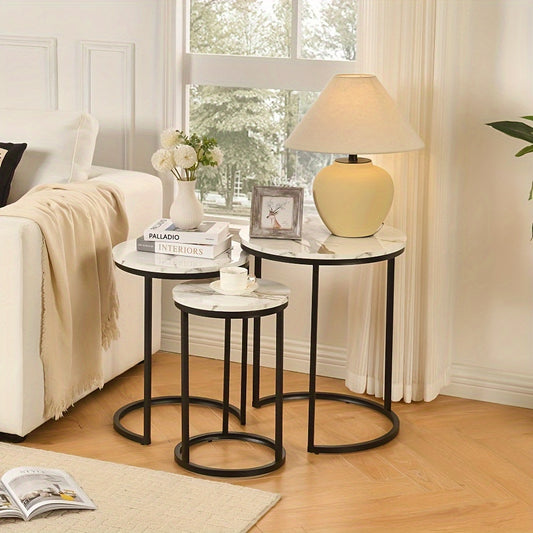 Nutshell modern side table set with three marble tops and black metal frames in cozy living room