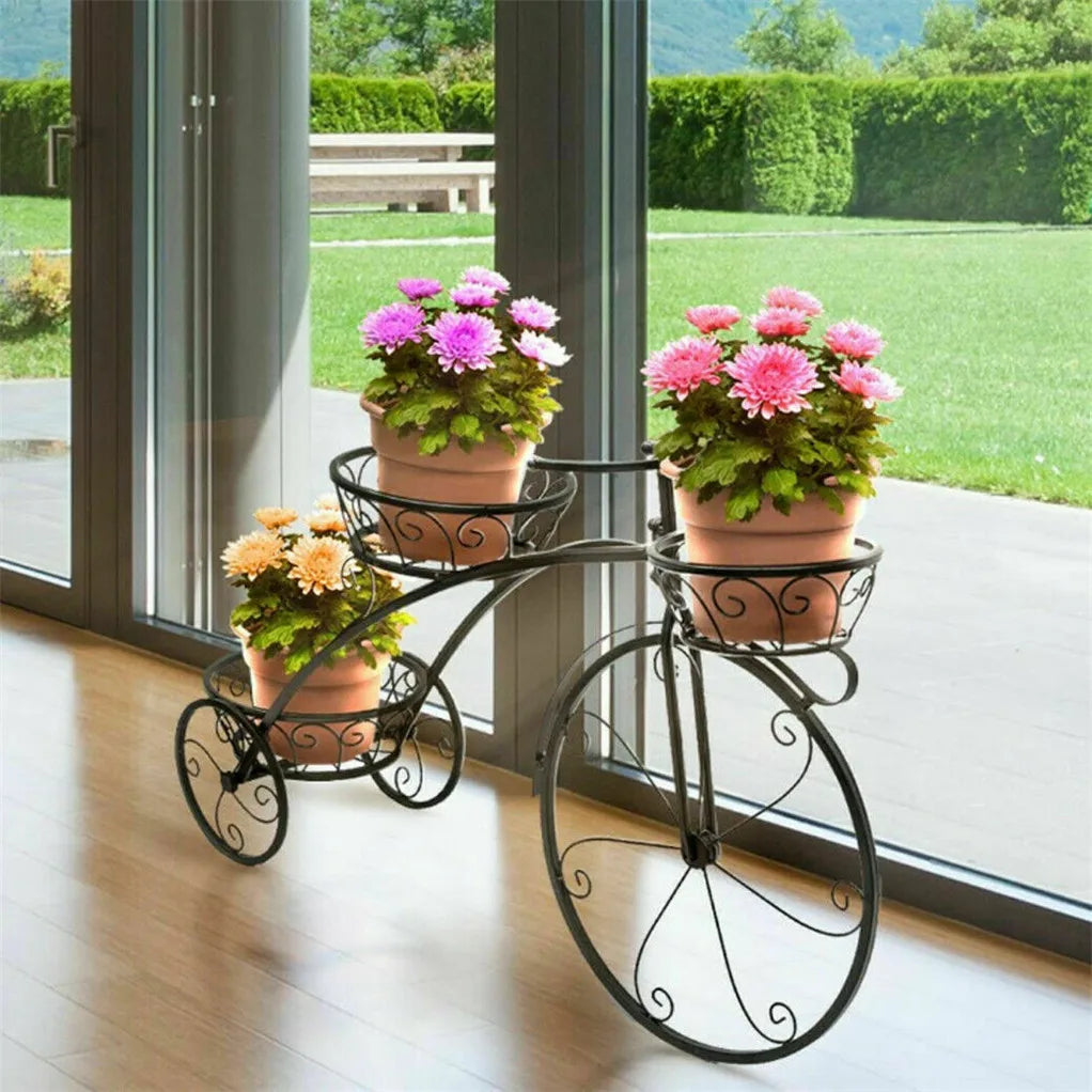 Nutshell rustic iron flower stand designed as a decorative black bicycle holding three potted colorful flowers