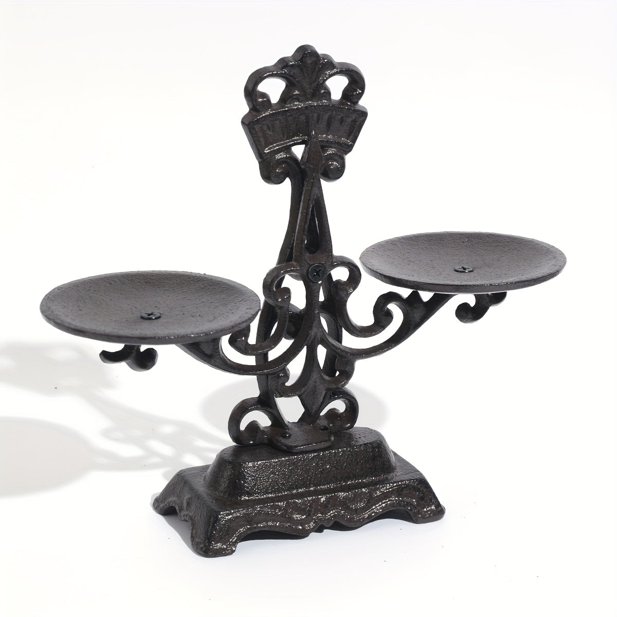 Vintage cast iron candle holder featuring an elegant design with two candle plates