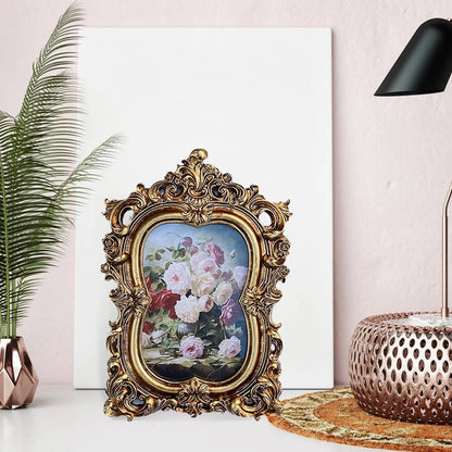 Vintage gold resin photo frame with intricate floral design displayed on a decorative table