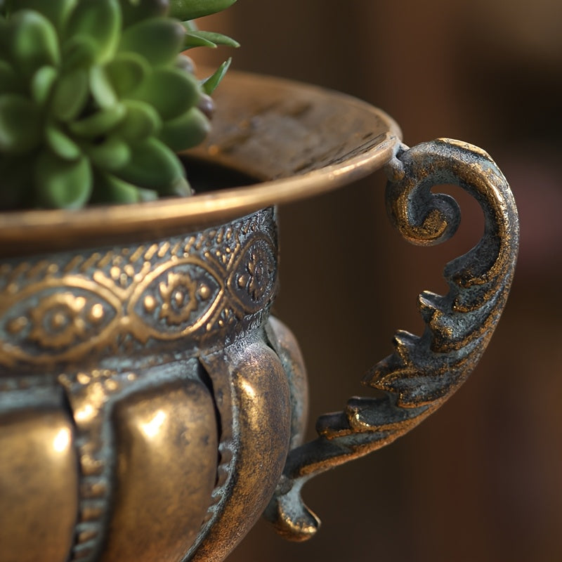 Close-up of vintage wrought iron pot with ornate handle and decorative detailing holding a green succulent