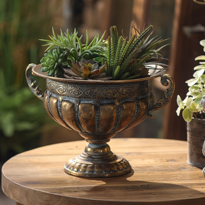 Nutshell vintage wrought iron pot vase with ornate handles filled with green succulent plants