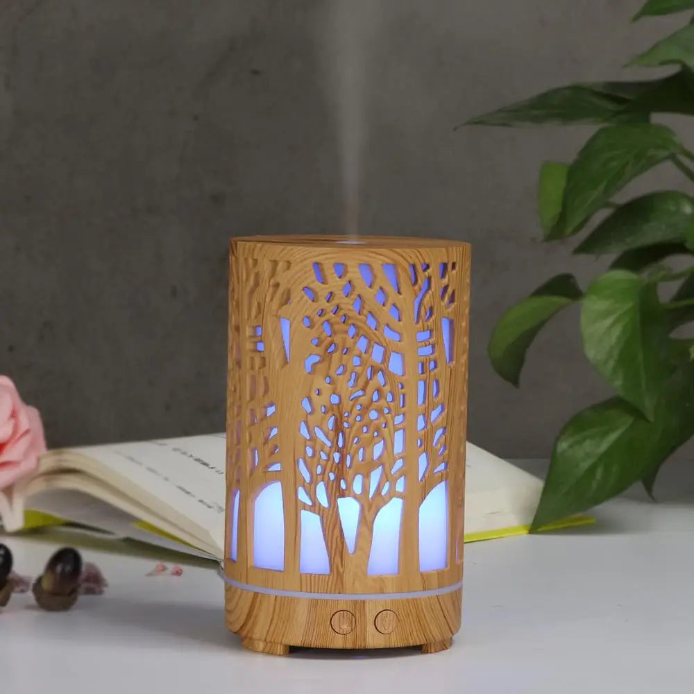 Nutshell wood grain essential oil diffuser with tree design and soft blue light on white surface