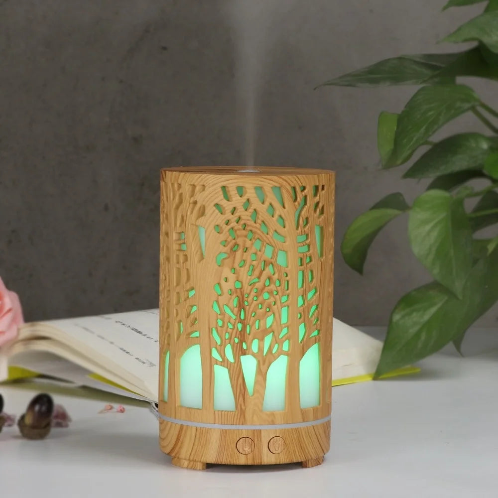 Nutshell wood grain essential oil diffuser with tree pattern and glowing green light misting on white table