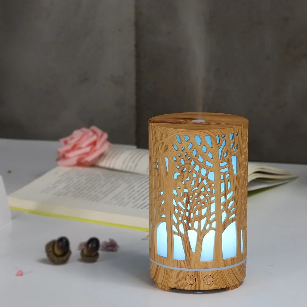 Nutshell wood grain essential oil diffuser with tree design and blue light misting on white surface