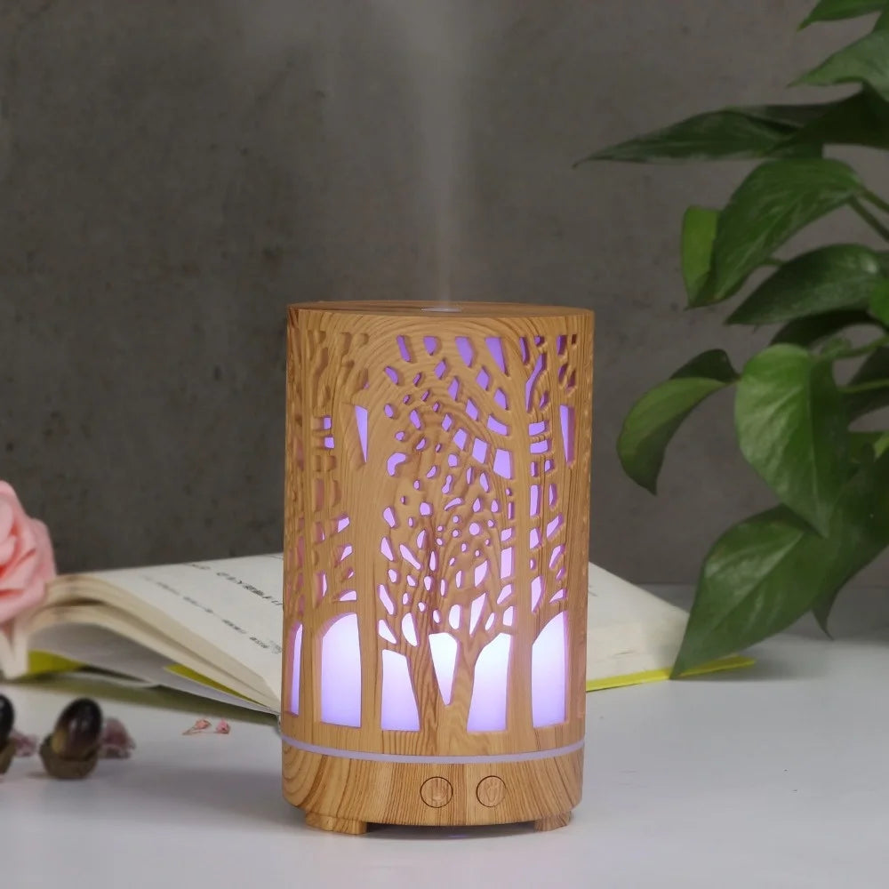 Nutshell wood grain essential oil diffuser with tree cutout design and purple light on white table