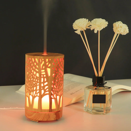 Nutshell wood grain essential oil diffuser with tree pattern and warm light next to reed diffuser sticks