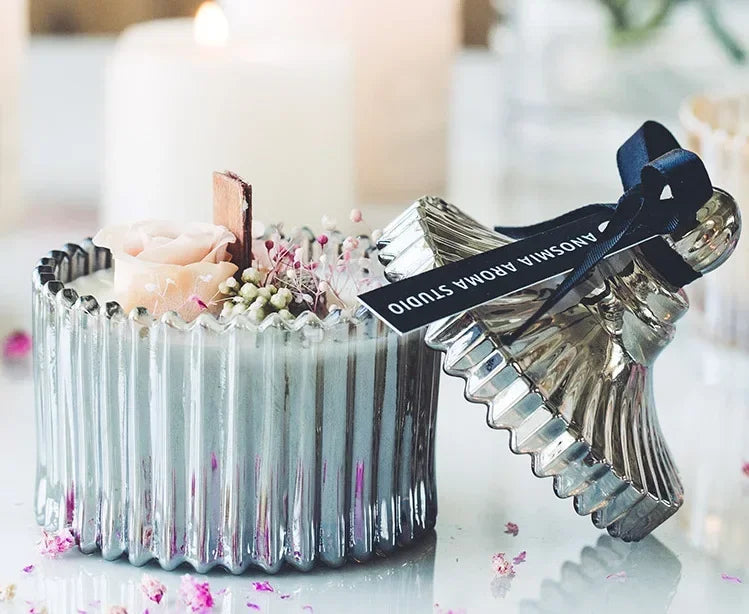 Nutshell candle with wooden candle wick in a ribbed glass container decorated with dried flowers
