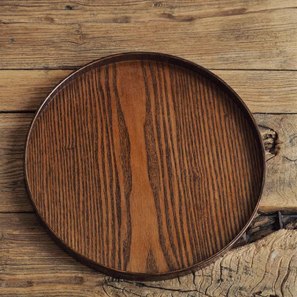 Nutshell round wooden serving tray with rich wood grain on rustic wooden surface