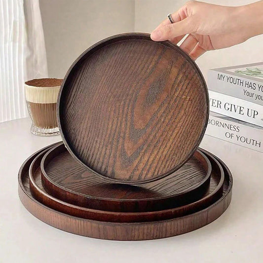 Nutshell wooden serving tray set with round dark brown wood grain trays stacked on a white surface