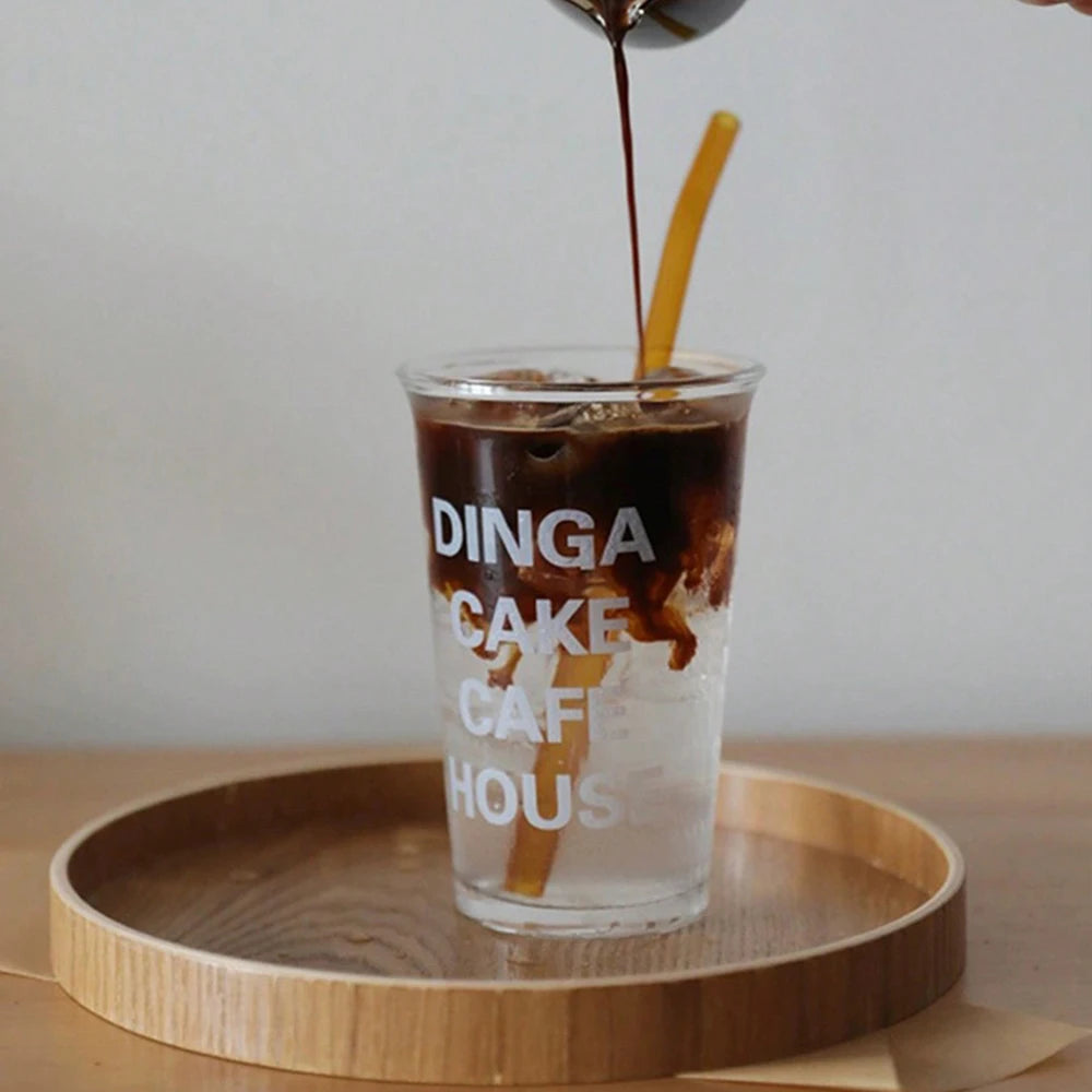 Nutshell wooden serving tray with a glass of iced coffee being poured on a wooden table