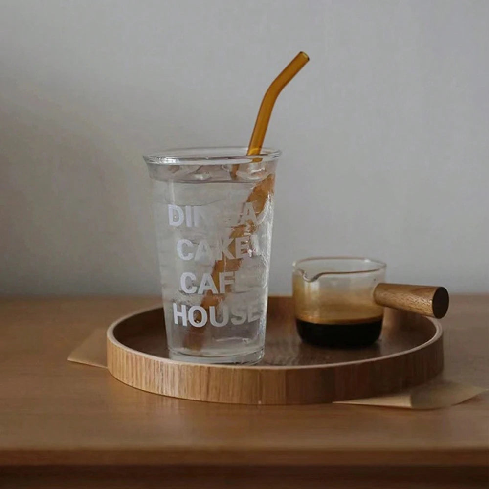Nutshell wooden serving tray with glass of iced water and espresso cup on wooden table