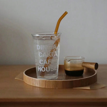 Nutshell wooden serving tray with glass of iced water and espresso cup on wooden table