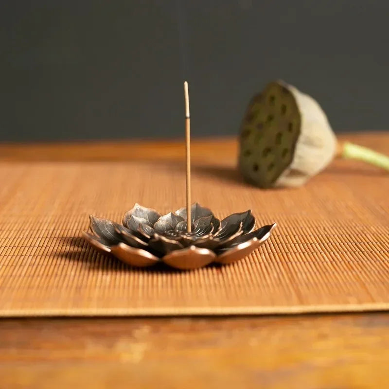 Nutshell Zen lotus incense burner shaped like a lotus flower holding a lit incense stick