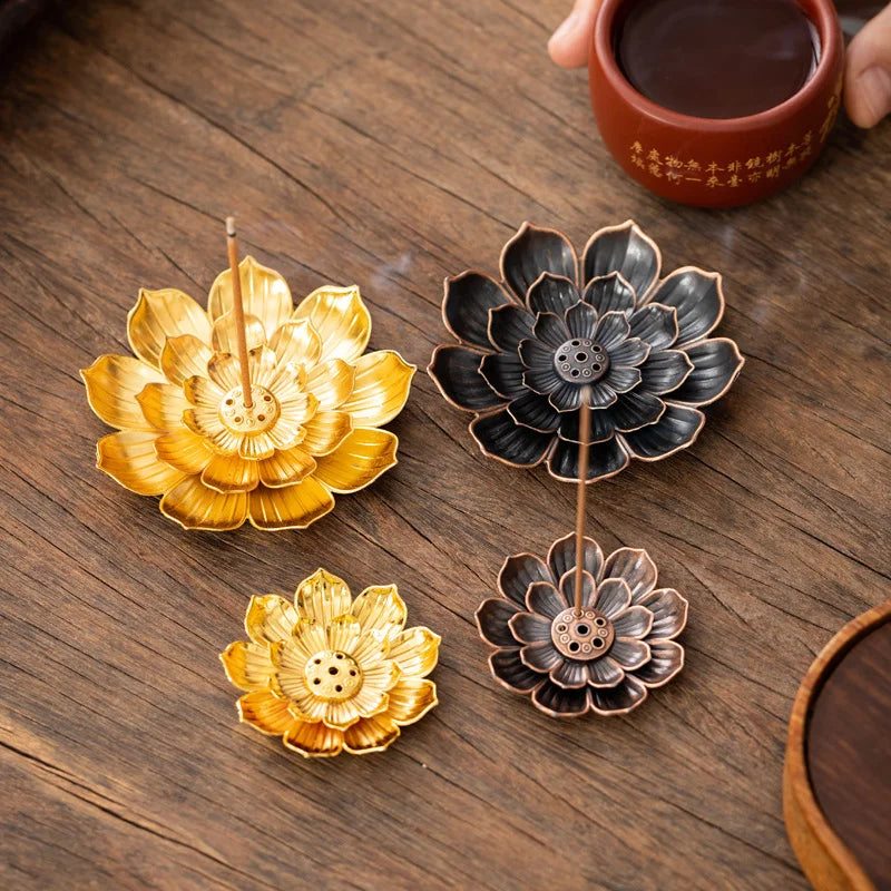 Nutshell Zen lotus incense burner set in gold and black lotus flower designs on wooden surface