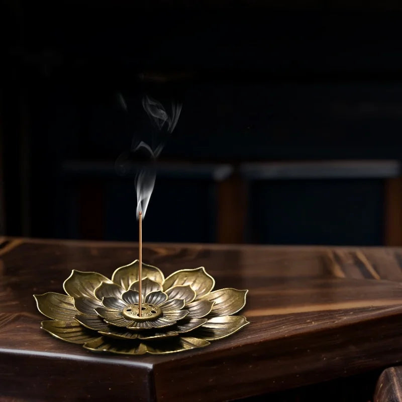 Zen lotus incense burner by Nutshell in brass with detailed lotus petals holding a burning incense stick