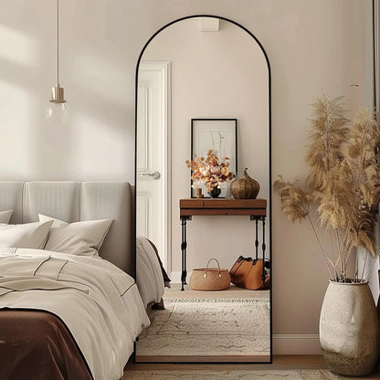 Nutshell arched full length floor mirror with slim black frame leaning in a modern bedroom